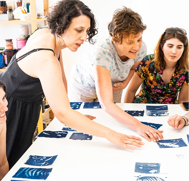 Drie vrouwen bezig met zeefdruk workshop